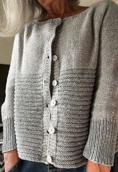 an older woman with grey hair wearing a gray cardigan