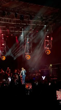 a man standing on top of a stage holding a microphone