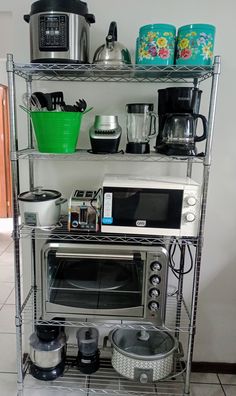 there is a microwave, toaster and other kitchen items on this shelving unit