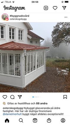 an instagram photo of a white house with red roof and awnings on it