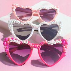 Add a Touch of Glamour to Your Bachelorette Bash with Custom Pearl Heart-Shaped Sunglasses! Make your bridal party unforgettable with our custom, handmade pearl heart-shaped sunglasses. Perfect for your Bachelorette party, Bridesmaids, or even your Honeymoon, these stylish shades are the ultimate accessory to add fun and elegance to your special event. Why You'll Love Them: Personalized Perfection: Choose between Gold or Black Letters and customize the message on each pair to match your celebration. Handcrafted Luxury: Every pair is adorned with pearls, rhinestones, and your custom saying, ensuring a unique and glamorous look for all your photos. Versatile for Any Occasion: Whether it's a Bridal Party, Engagement Party, Bachelorette, or Honeymoon, these sunglasses are the perfect way to sh Bridal Sunglasses Polarized, Bridal Sunglasses, Bride Sunglasses, Bachelorette Sunglasses, Wedding Sunglasses, Handmade Sunglasses, Bachelorette Party Bride, Shaped Sunglasses, Diy Bridal