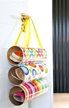 three rolls of toilet paper hanging on a wall with a yellow bag in the background