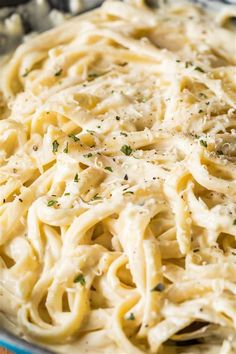 a close up of a plate of pasta with parmesan cheese and herbs on top