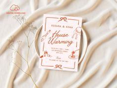 an orange and white wedding card sitting on top of a bed