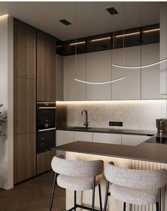 the modern kitchen has two bar stools and an island in front of it,