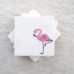 a pink flamingo sitting on top of four napkins