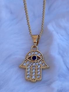 Hamsa Evil Eye Charm pendant  Necklace,  CZ stones on Hamsa Hand   Brazilian Gold Layered, Great Quality  Measures 20 inches in length Gold Spiritual Jewelry With Rhinestones, Gold Plated Jeweled Necklaces As Gifts, Gold-plated Crystal Necklace, Gold Chain Necklace With Rhinestones As Gift, Gold Chain Necklace With Rhinestones For Gift, Hand Set Gold Crystal Necklace, Gold Jeweled Chain Necklace Gift, Spiritual Gold Necklaces With Hand-set Details, Spiritual Gold Necklaces With Hand Set Details