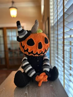 a knitted pumpkin sitting on top of a wooden table