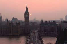 the sun is setting over big ben and the river thames in london, united kingdom