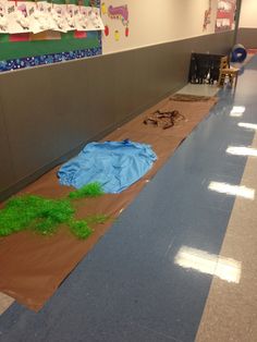 an empty room with blue tarp and green grass on the floor