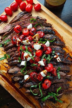 steak with cherry tomatoes and herbs on a cutting board