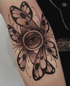 a woman's arm with a butterfly tattoo on it and an eye in the center