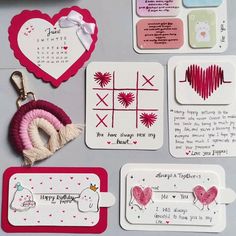 some cards and magnets on a table with hearts, arrows, and other items