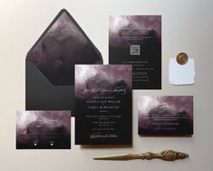 the wedding stationery is set up with black and purple watercolors