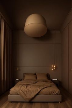 a large bed sitting under a hanging light in a bedroom next to a wooden floor