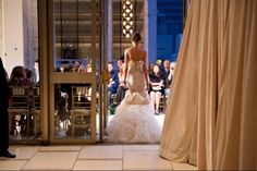 a woman in a wedding dress walking into a building