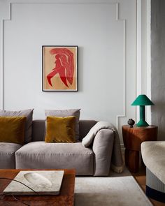 a living room with a couch, coffee table and pictures on the wall above it