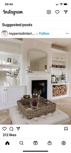 a living room with white furniture and a fireplace in the center, on instagram