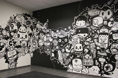 the wall is decorated with black and white doodles in an office lobby area