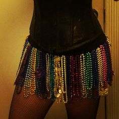 a woman wearing a black corset with lots of beads on it