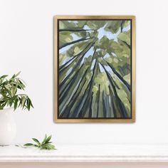 a painting hanging on the wall next to a potted plant