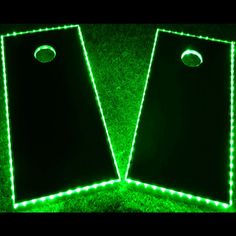 two green cornholes with lights on them