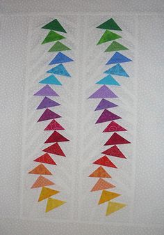 a quilted wall hanging with different colored triangles on it