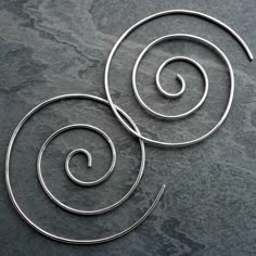 Large sterling silver spiral earrings. Hand formed and hammered, these spiral earrings are light and lovely. Thread them through your earlobe starting from the back, keep going until the post is behind your ear for an unbroken spiral look. Spirals are approximately 1 5/8" across. Handmade of solid sterling silver.For more earrings:https://www.etsy.com/shop/KiraFerrer?section_id=7937255&ref=shopsection_leftnav_3You may also like:https://www.etsy.com/shop/KiraFerrer?ref=hdr_shop_menu&view_ Swirl Earrings Spirals, Spiral Hoop Earrings, Funky Silver Earrings, Spiral Jewelry, Silver Threader Earrings, Earring Hole, Swirl Earrings, Spiral Earrings, Funky Jewelry