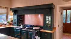 a kitchen with green cabinets and an oven