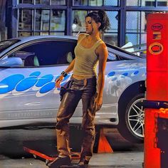 a woman riding a skateboard next to a parking meter