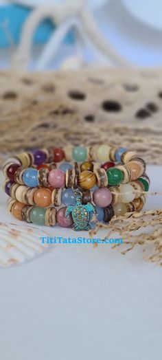 TitiTataStore.com Always FREE SHIPPING and a FREE GIFT! I Will Ship Within 24 Hours! Description: This listing is for A Set of Three Handmade Tropical Style Bracelets.  A Multicolor Summer Beach Bracelets Delight!   Materials: 8mm Natural Gemstones, 8mm Wood Beads, and Coconut Shells Beads. A lovely Sea Turtle adorned this beachy set.  Every Bracelet in my shop is handmade by me using high quality materials. A high-quality elastic stretch cord is used to string the beads together. Size: Each bra Multicolor Hippie Bracelets For Vacation, Spiritual Friendship Bracelets With Round Beads For Beach, Beachy Multicolor Friendship Bracelets For Vacation, Multicolor Beaded Bracelets For Beach, Colorful Hippie Beach Bracelets, Multicolor Beaded Bracelets For Beach Season Gift, Multicolor Tropical Jewelry For Beach, Colorful Hippie Beach Jewelry, Tropical Style Multicolor Jewelry For Beach