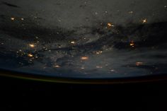 the earth's night sky is seen from space, with lights shining on it