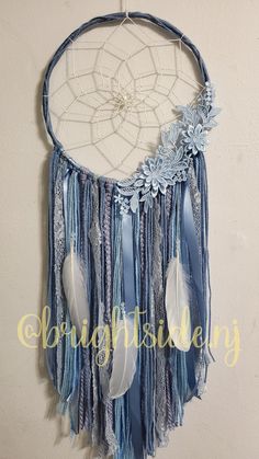 a blue and white dream catcher hanging on the wall