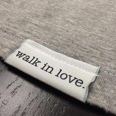 a label that says walk in love on the side of a shirt with words written on it