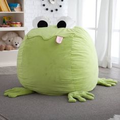 a large green frog sitting on the floor