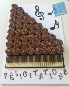 a cake shaped like a piano with music notes on it's side and the words dedication written below