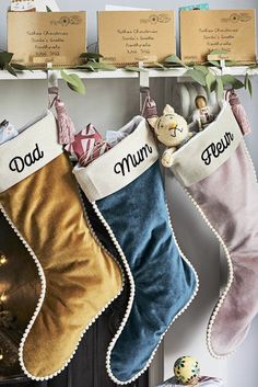 three christmas stockings hanging on a mantle with the word dad and mum written on them