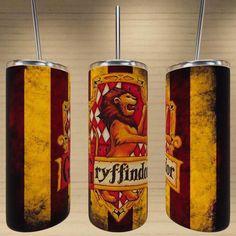 two red and yellow tumblers with lions on them, one has a metal straw in it