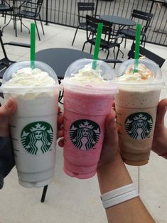 three starbucks drinks in plastic cups with green straws