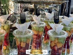 there are many different types of fruit in plastic cups with forks on the top and bottom