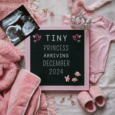 a sign that says tiny princess arriving december 2012 next to pink baby clothes and shoes