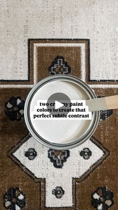 a paint can sitting on top of a rug next to a wooden spatula with the words twerlver pyronit colors or create that perfect table contrast