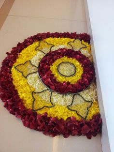 a cake decorated with yellow and red flowers on top of a white table next to a cupcake