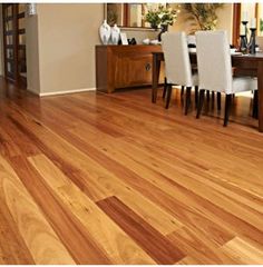 there is a wooden floor in the living room with white chairs and a wood table