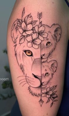 a woman's thigh with a lion and flower tattoo on her leg, the other side has an arrow in it