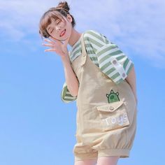 a woman is posing with her hand up to her face while wearing a green and white striped shirt