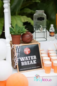 a table topped with drinks and basketballs on top of it