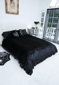 a bedroom with white carpet and black bedding