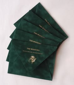 six green envelopes with gold lettering on them sitting next to each other in front of a white background