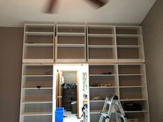 a ladder is in front of a bookshelf that has several shelves on it